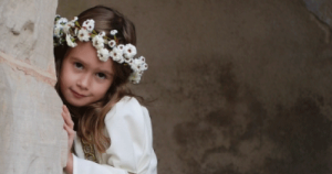 Small girl with garland of white flowers in her hair