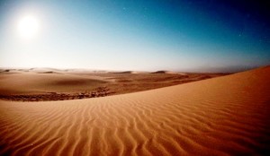 Photograph of a sand desert with blazing sun