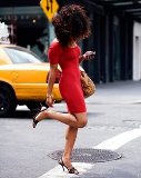 Woman in red dress with New York taxi