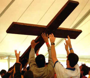 Young people raising a wooden cross