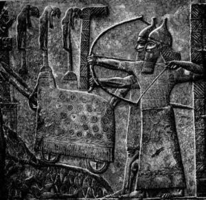 Assyrian archers, a city under siege with siege machines to batter down the walls; prisoners impaled on the city walls; carved wall relief