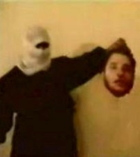 Masked man holding decapitated head