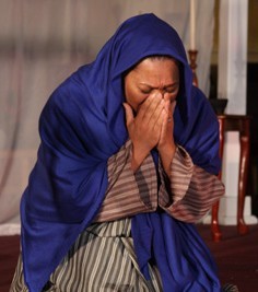 A kneeling woman pleads