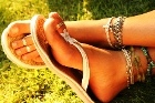 Well-groomed feet of a woman, with foot and ankle jewelry