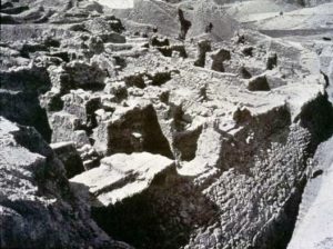 Excavated revetment wall at ancient Jericho; notice the human figure at the bottom right of the 19th century photograph