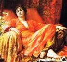 Woman dressed in luxurious red, lying on a silken couch