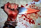 Blood-spattered woman's hand holding a sharp knife
