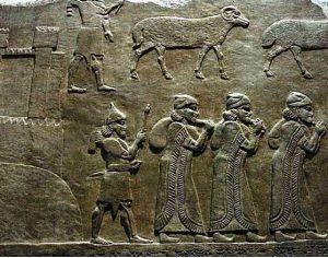 High-ranking (denoted by their long fringed robes) Assyrian officials carry away the loot from the